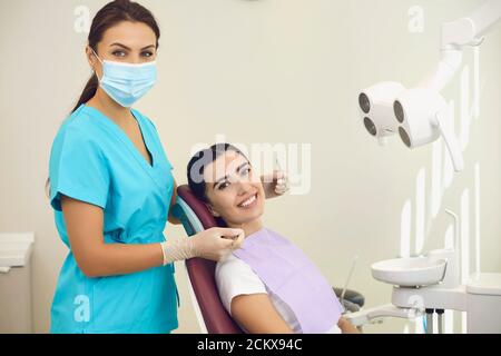 Porträt einer freundlich lächelnden Zahnärztin mit einem Patienten im Büro einer Zahnklinik. Stockfoto