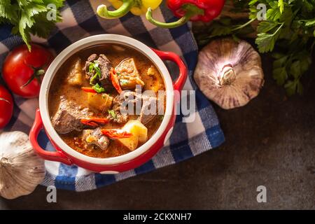 Blick von oben auf eine Schüssel Gulaschsuppe mit Fleisch, Kartoffeln und Chilis Stockfoto