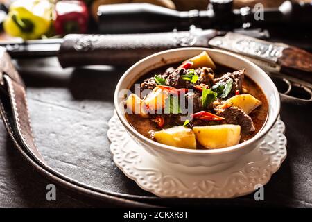 Hirsch Eintopf in einer Schüssel Jagdwaffe als Dekoration Stockfoto