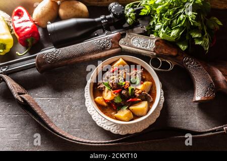 Hirsch Eintopf in einer Schüssel Jagdwaffe als Dekoration Stockfoto