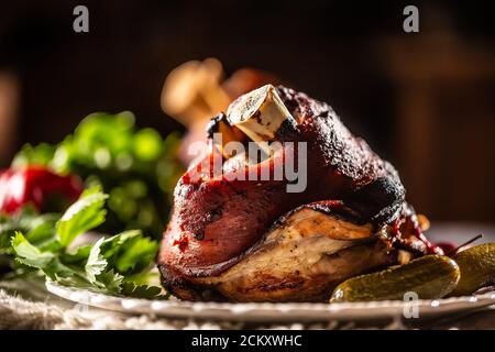 Geräucherter Schweinshaxe, Schweineknee serviert mit eingelegten Gurken und Kräutern Stockfoto