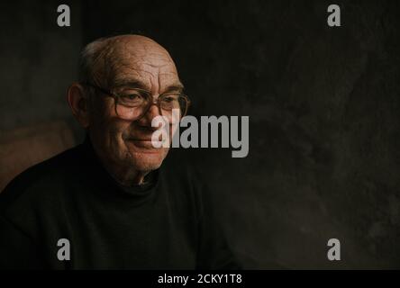 Nachdenklicher alter Mann in einer Brille mit grauem Haar Stockfoto