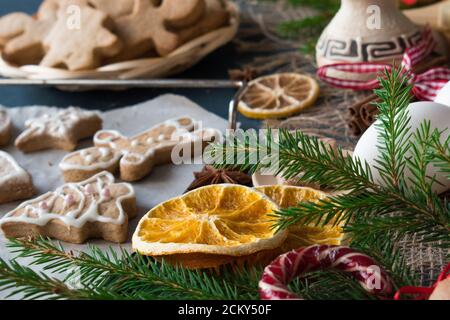 Nahaufnahme eines Fichtenzweiges und orangefarbene Scheiben auf dem Hintergrund von glasierten Cookies. Stockfoto