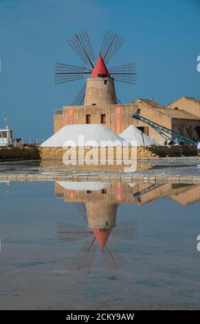 Rote Windmühle und natürliches Salz im rosa Meer von Marsala. Kochsalzlösung Ettore Infersa, Sizilien. Naturschutzgebiet und Salzmuseum. Stockfoto