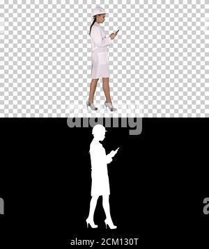 Techniker, der unterwegs SMS per Mobiltelefon verwendet, Alpha Channel Stockfoto