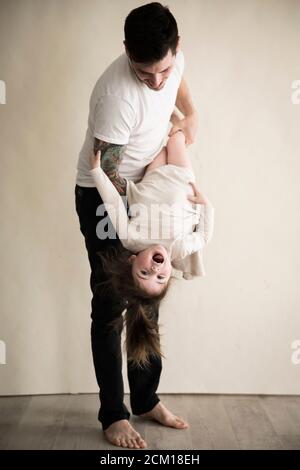 Happy Tattooed Millennial Dad Hält Tochter Des Kleinkindes Auf Den Kopf Stockfoto