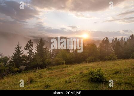 Tolle Berglandschaft mit bunt leuchtenden Sonnenuntergang auf dem bewölkten Himmel, natürliche Outdoor reisen Hintergrund. Beauty Welt. Stockfoto