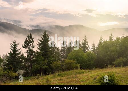 Tolle Berglandschaft mit bunt leuchtenden Sonnenuntergang auf dem bewölkten Himmel, natürliche Outdoor reisen Hintergrund. Beauty Welt. Stockfoto