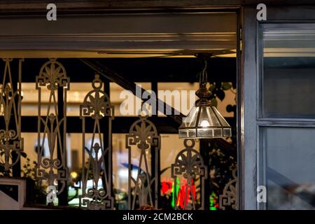 Kronleuchter mit transparentem Glas und eine Glühbirne an der Decke eines Cafés mit einem Holzfenster und einer eisernen Treppe Retro-Restaurant Interieur, Nobo Stockfoto