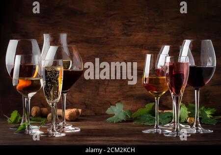 Weinverkostungskonzept, Stillweine und Schaumweine. Rot, Weißwein, Rose und Champagner in Weingläsern auf Vintage Holztisch Hintergrund Stockfoto