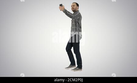 Glücklich lächelnd Gehen gut aussehend bärtig jungen Mann macht Selfie o Stockfoto