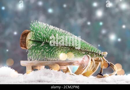 Kleiner Weihnachtsbaum auf Holzschlitten oder Schlitten, Silvester verschneiten Hintergrund, Weihnachtskonzept Stockfoto