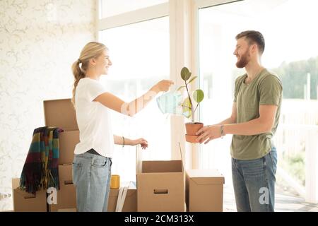 Paar Auspacken bewegliche Kartons und halten Blume in Topf Stockfoto