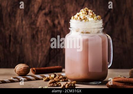 Winter heiße dunkle Schokolade mit Schlagsahne und zerkleinerten Walnüssen im Glas, Kopierraum Stockfoto