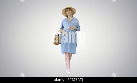 Attraktive schwangere Frau lächelnd und zu Fuß auf Steigung backgr Stockfoto