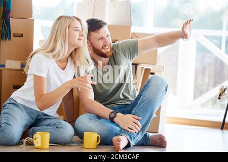 Paar in der Nähe von Kartons in neue Wohnung entspannen nach dem Auspacken Boxen verheiratet Stockfoto