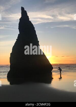 Der Tourist am Oregon Beach macht ein Foto des beliebten Meeresstapels. Stockfoto