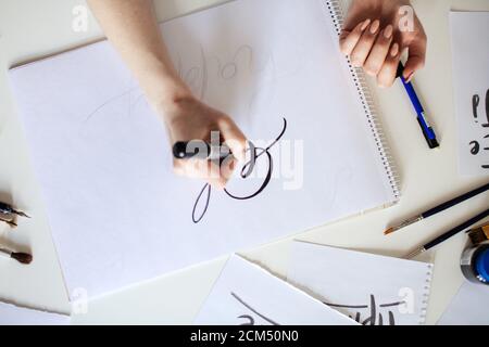 High-Angle-Ansicht der Frau Hände schreiben Oh Worte auf Whitepaper Stockfoto