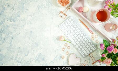 Rouge rosa Thema gemütliche Hygge Desktop-Arbeitsplatz mit Tastatur Smartphone Tee und Rose auf einem stilvollen weißen Marmor texturierten Hintergrund. Top View Blog-Held Stockfoto