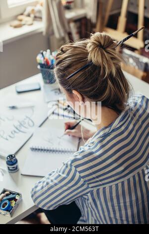 High-Angle-Ansicht der Frau Hände schreiben Oh Worte auf Whitepaper Stockfoto