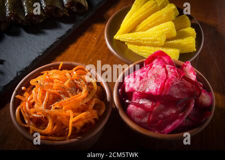 Verschiedene eingelegte Gemüse in Tonteller auf dem Tisch Stockfoto