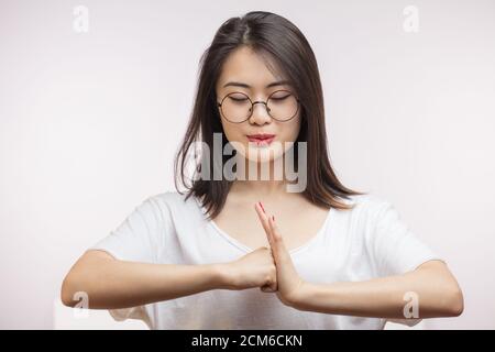 Asiatische Frau hält die Hände in Gruß mit Thai Kultur Zeichen, gibt warmen Empfang isoliert auf weißem Hintergrund. Stockfoto