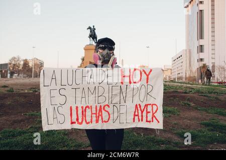 SANTIAGO, CHILE - 11. SEPTEMBER 2020 - EINE junge Frau protestiert mit einem Zeichen, das sagt: "Der Kampf von heute ist auch für die Kämpfe von gestern". Hunderte von Stockfoto