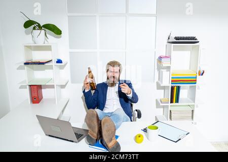 Müde gelangweilte Geschäftsmann Gähnen am Arbeitsplatz in der Nähe von Laptop, langweilige Arbeit, Sackgasse Job, Überarbeit extra nach Stunden, Alkohol trinken. Betrunkener Büroangestellter. Stockfoto