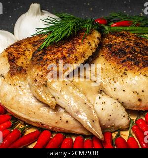 Gebratenes Huhn, gebratenes halbes Huhn, serviert Gemüse, lecker, bestreut mit Gewürzen, Knoblauch und roten heißen Mini-Pfeffer Stockfoto