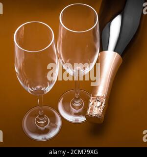 Zwei Sektgläser und eine Flasche auf braunem Hintergrund Stockfoto