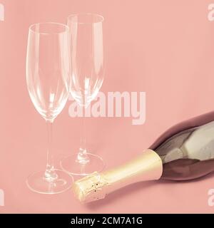 Zwei Sektgläser und eine Flasche auf rosa Hintergrund Stockfoto