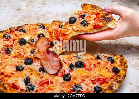Machen Sie eine Pizza zu Hause mit Tomaten, Oliven, Schinken und Käse, Kochen zu Hause Konzept. Stockfoto