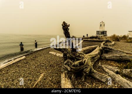 Fischer in Puget Sound in der Nähe von Bown's Point Leuchtturm in der Waldbrand Dunst Stockfoto
