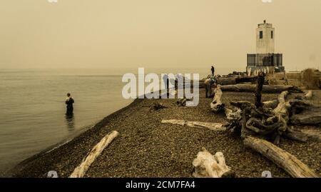 Fischer in Puget Sound in der Nähe von Bown's Point Leuchtturm in der Waldbrand Dunst Stockfoto