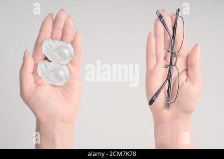 Frau mit Brille und Kontaktlinse auf weißem Hintergrund, selektiver Fokus auf Brille, Myopie und Sehfehler Konzept. Stockfoto