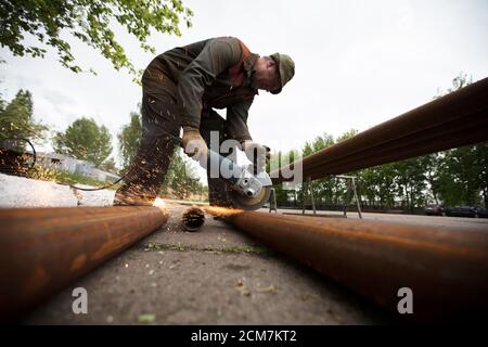 Arbeiter schneidet ein Rohr in der Fabrik. Stockfoto