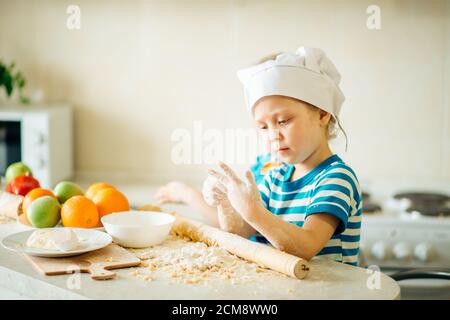 Kochen macht Spaß. Kleine Mädchen spielen mit Mehl Stockfoto