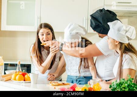 Familie macht Pizza zum Abendessen und essen Stockfoto