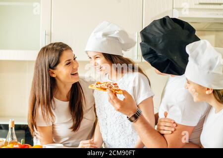 Familie macht Pizza zum Abendessen und essen Stockfoto