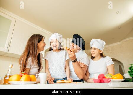 Familie macht Pizza zum Abendessen und essen Stockfoto