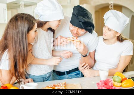 Familie macht Pizza zum Abendessen und essen Stockfoto
