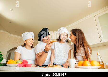 Happy Family essen Pizza auf dem hölzernen Tisch Stockfoto