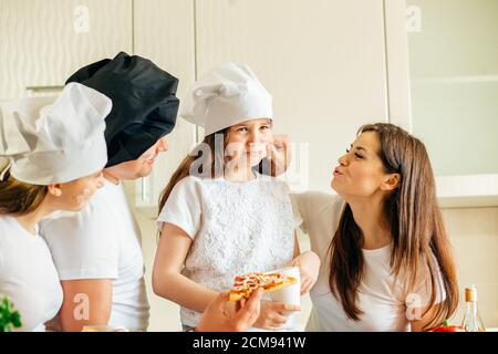 Familie macht Pizza zum Abendessen und essen Stockfoto
