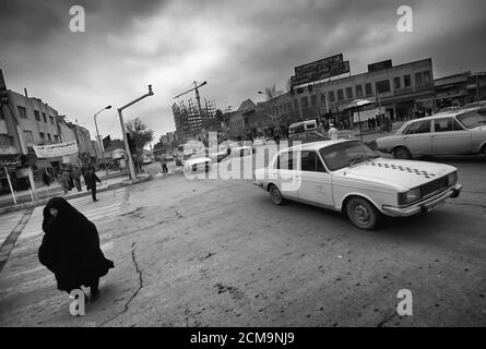 Mashhad, Iran - Februar 14,2008: Mashhad ist die zweitgrößte Stadt im Iran.Mashhad ist eine heilige Stadt für schiitische Muslime.Frau im Verkehr zu Fuß. Stockfoto