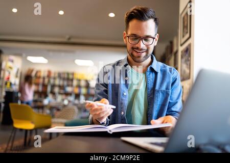 Der Schüler bereitet die Prüfung und den Lernunterricht in der Schulbibliothek vor Stockfoto