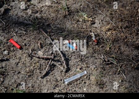 Gebrauchte gebrochene medizinische Nadel, Kappe und Pillen liegen auf dem Boden Stockfoto