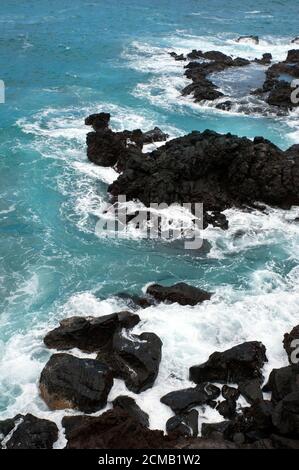 Vertikale Perspektive mit schaumigen Wellen, wütenden Ozean, krachend auf den schwarzen vulkanischen Felsen, in Puerto de la Cruz, Teneriffa, Kanarische Inseln, Spanien Stockfoto