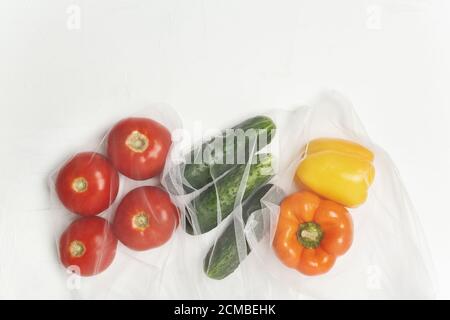 Wiederverwendbare Beutel mit, frisches Gemüse Tomaten, Gurken, Paprika auf weißem Hintergrund, Zero Waste Konzept Stockfoto