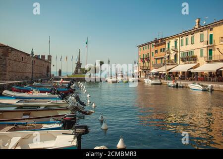 Dogana Veneta und Porticciolo in Lazise, in Italien mit farbigen Booten Stockfoto