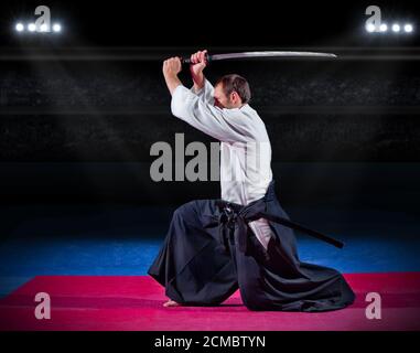 Aikido Kämpfer mit Schwert in der Sporthalle Stockfoto